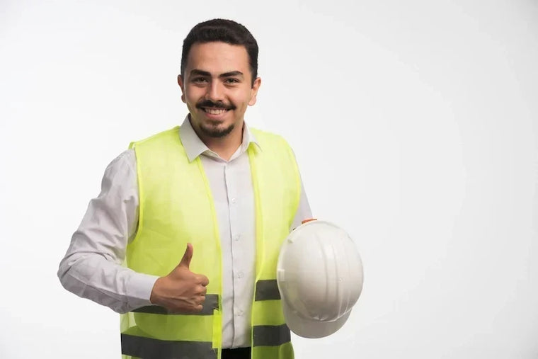 General industry safety professional in a high-visibility vest holding a hard hat.